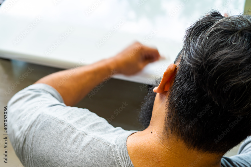 White laminated sticker on the furniture. Man installing sticker at home. Selective focus. White laminated sticker on the furniture. Man installing sticker at home. Selective focus.