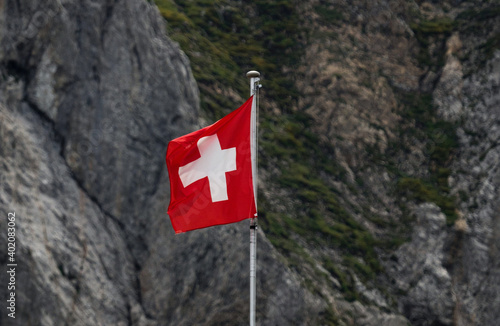 Swiss flag waving in the wind in Alpstein mountains alpine rocky background Appenzell Switzerland photo