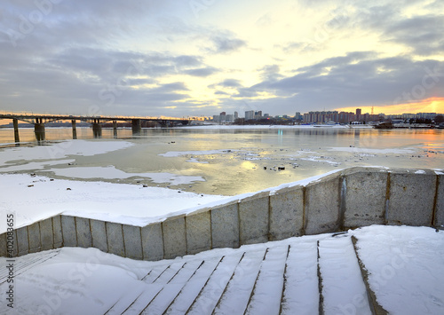 Embankment of the river Ob in Novosibirsk. Granite stairs, Oktyabrsky automobile bridge on a winter evening, Gorsky district photo