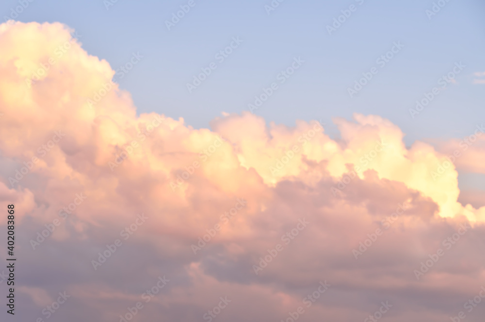 The clouds in the sky. Golden fluffy clouds on a blue background