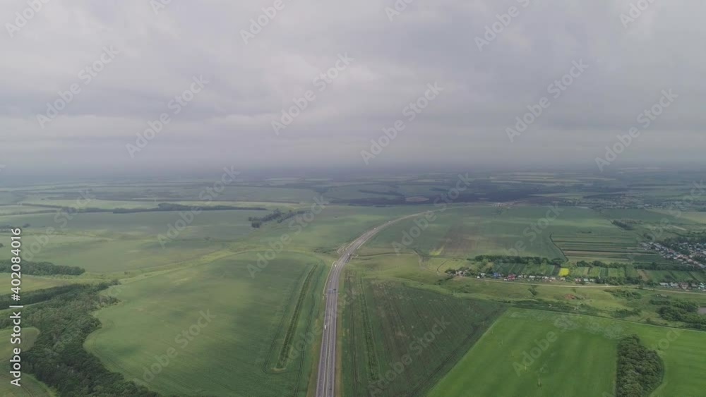 Flight over the highway. The road runs through green fields Flight over the highway. The road runs through green fields