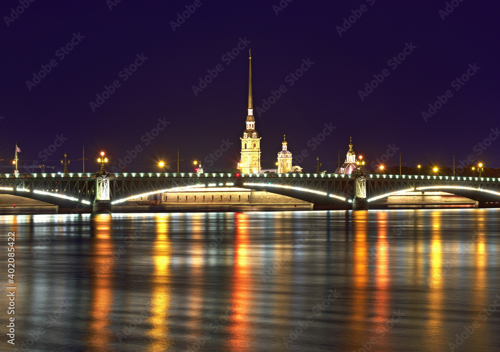 Night city. View of the Trinity bridge and Peter and Paul Cathedral in the night lights reflected in the waters of the Neva. Architecture of the XVIII century