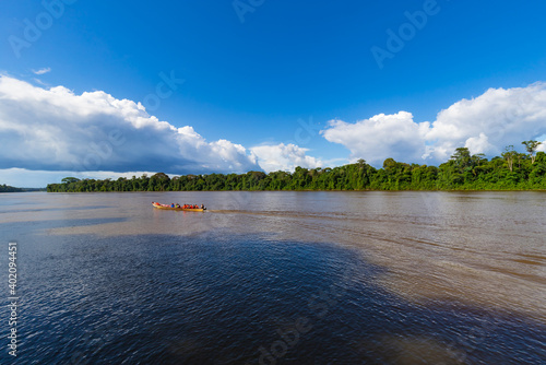 Brokopondo, Suriname - August 2019: Cloud Formation Background With Boat Sailing Along River On Sunny Day. Rainforest Landscape Scenery In South America.