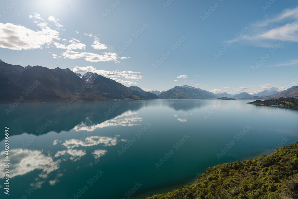 Panoramic view of mountains reflected in the water of Lake Wakatipu. Bennets bluff lookout, New Zealand.