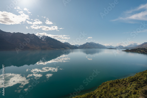 Panoramic view of mountains reflected in the water of Lake Wakatipu. Bennets bluff lookout, New Zealand.