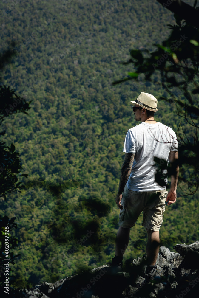 Young man in the middle of the forest admiring nature. Travel concept