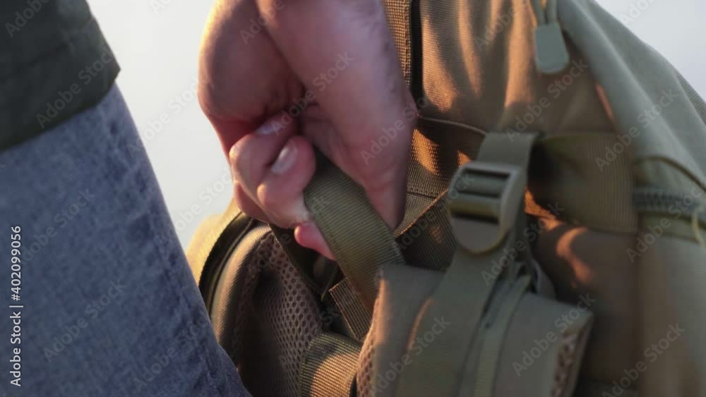 Hiking hobby. Close up of man holds his backpack Hiking hobby. Close up of man holds his backpack