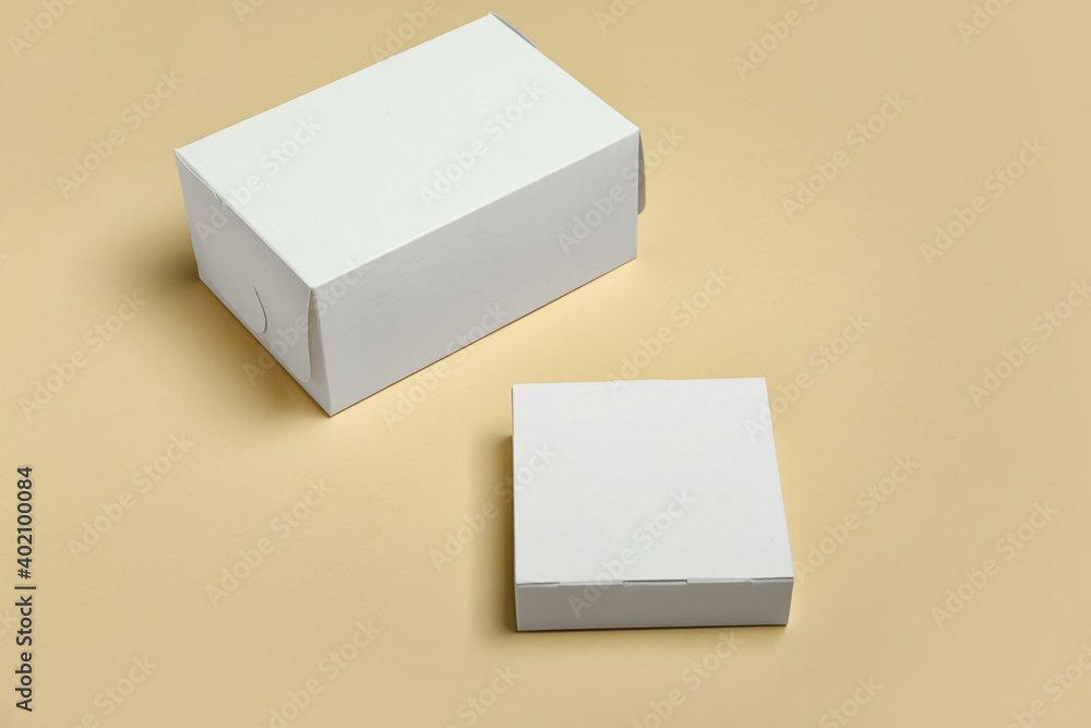 Blank cardboard boxes on color background