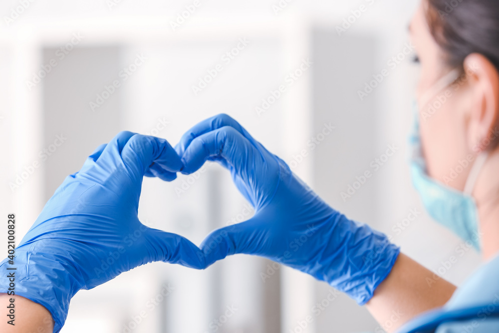 Female doctor showing heart shape with hands, closeup Female doctor showing heart shape with hands, closeup