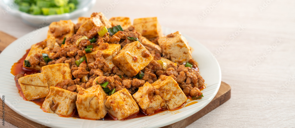 Mapo tofu, stir-fried tofu with hot spicy sauce in white plate. Mapo tofu, stir-fried tofu with hot spicy sauce in white plate.