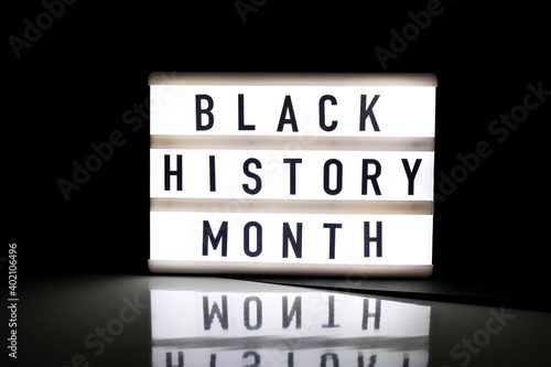 Lightbox with text BLACK HISTORY MONTH on dark black background with mirror reflection. Message historical event. photo