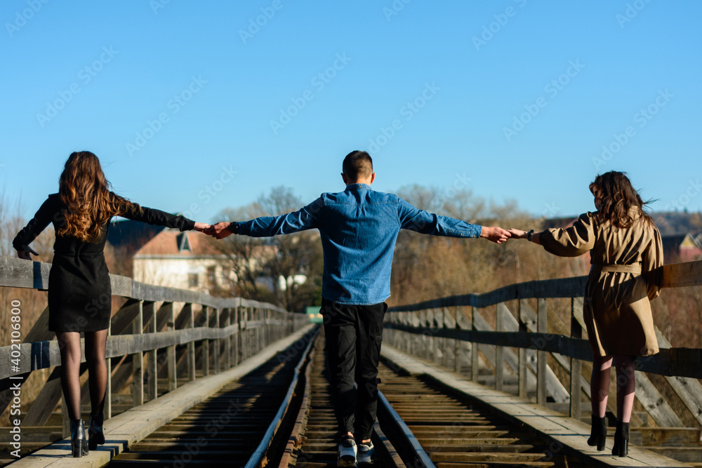 Teenagers walk on the railway bridge in autumn.