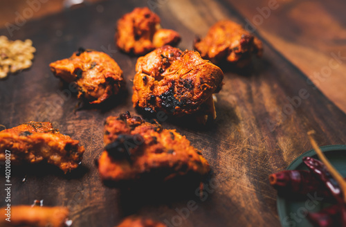 Close up of chicken tikka masala. Cooked meat coated in spicy indian sauce texture and details.