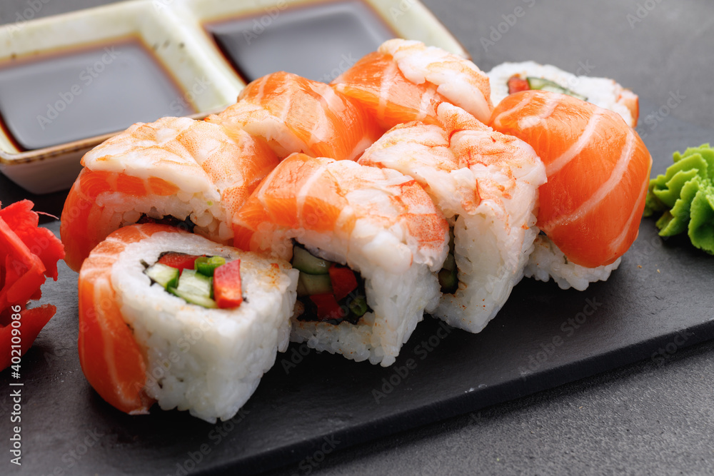 Sushi roll covered with salmon and prawn close up Sushi roll covered with salmon and prawn close up