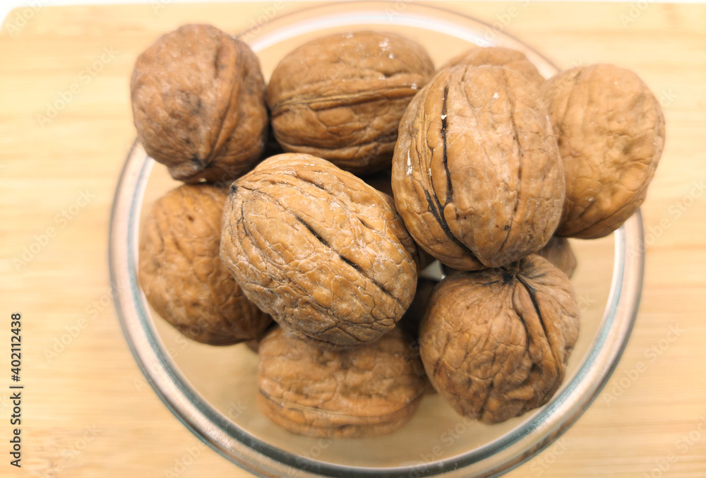 walnuts in a bowl,walnuts on a wooden table walnuts in a bowl,walnuts on a wooden table