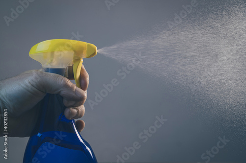 Person using spray desinfection bottle to clean areas infected with corona virus covid 19. Pressing with hands on a sanitizer plunger.