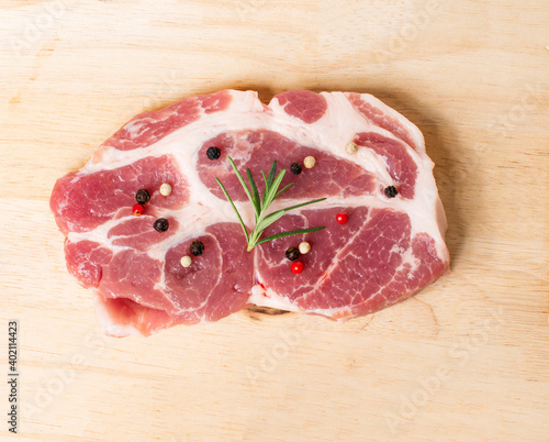 Raw meat with spices in wooden board isolated on wood background.