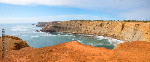 rocky coast Carrapateira, with red sandstone ground and view to the cliffs