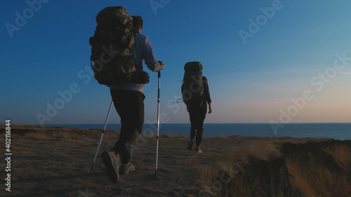 The two tourists walking in the mountains near the sea photo