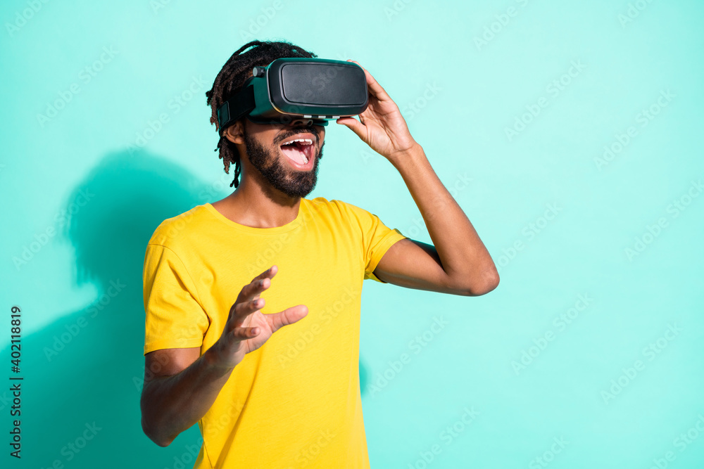 Photo of young excited crazy smiling amazed african man using vr glasses isolated on teal color background Photo of young excited crazy smiling amazed african man using vr glasses isolated on teal color background