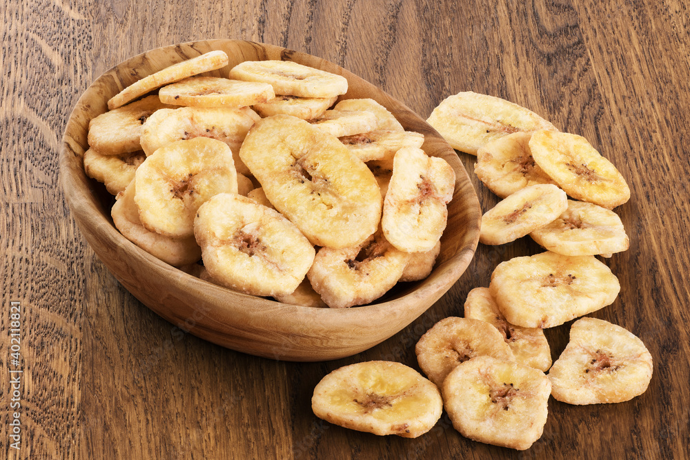 Dried bananas on wooden background.