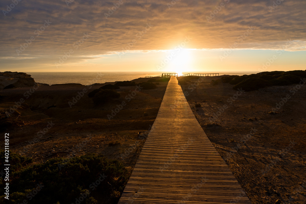 wooden boardwalk at sunset, coastal landscape Carrapateira West Algarve. cloudy sky