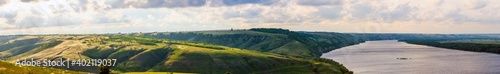 Beautiful countryside landscape. wide panoramic view of the river with a coastal meadow on the slope of a hilly coast © rostovdriver