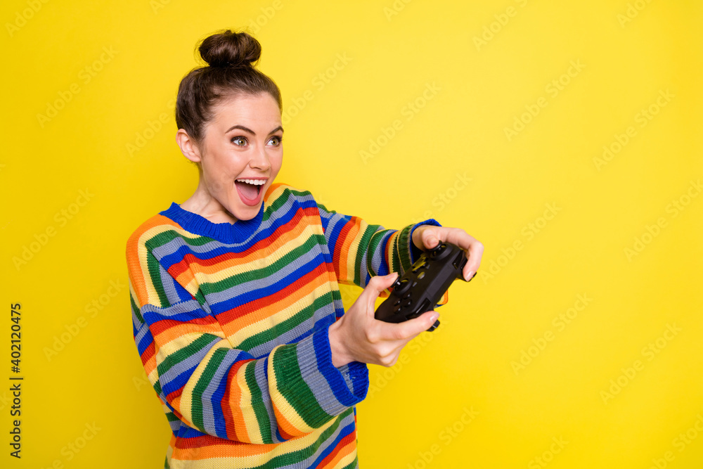 Profile side photo of young attractive woman happy positive smile play video games isolated over yellow color background Profile side photo of young attractive woman happy positive smile play video games isolated over yellow color background