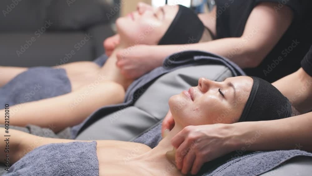 two cute Caucasian women enjoy facial and decollete beauty treatments at the spa. two cute Caucasian women enjoy facial and decollete beauty treatments at the spa.