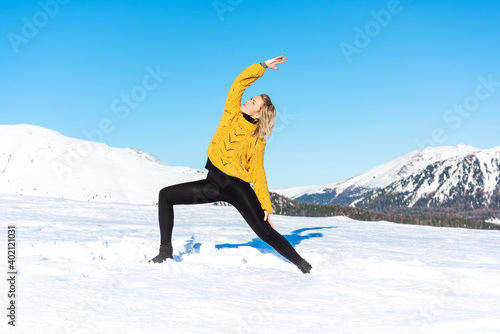 Woman practicing yoga in a landscape with snow in winter 