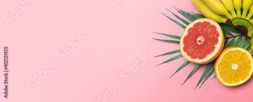 Fototapeta Naklejka Na Ścianę i Meble -  Tropical fruits summer banner background. Bananas, oranges and grapefruits on a colored pink background. Smoothie, summer vacation, sun and vitamins concept.
