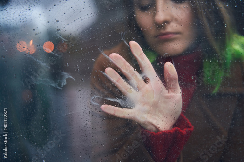 Woman sitting at the stairs and touching window