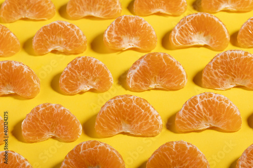 A top view closeup of tangerines slices on a yellow background photo