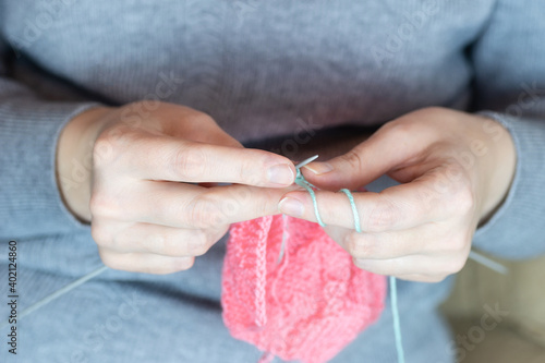 The girl knits with knitting needles