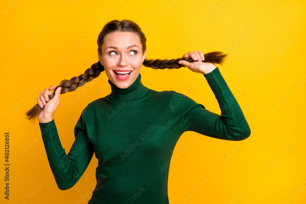 Photo portrait girl cheerful childish looking blank space smiling touching braids isolated vivid yellow color background Photo portrait girl cheerful childish looking blank space smiling touching braids isolated vivid yellow color background