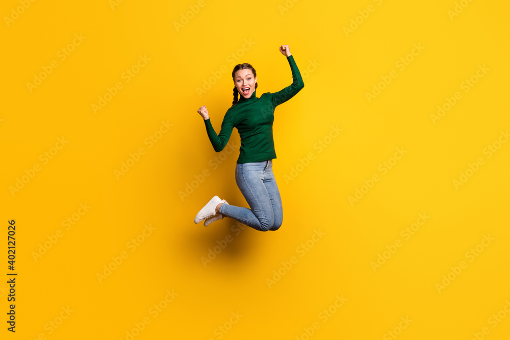 Full length body size photo smiling woman jumping high gesturing like winner isolated on bright yellow color background
