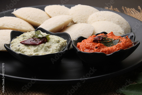 Idly sambar or Idli with Sambhar and green, red chutney. Popular South indian breakfast photo