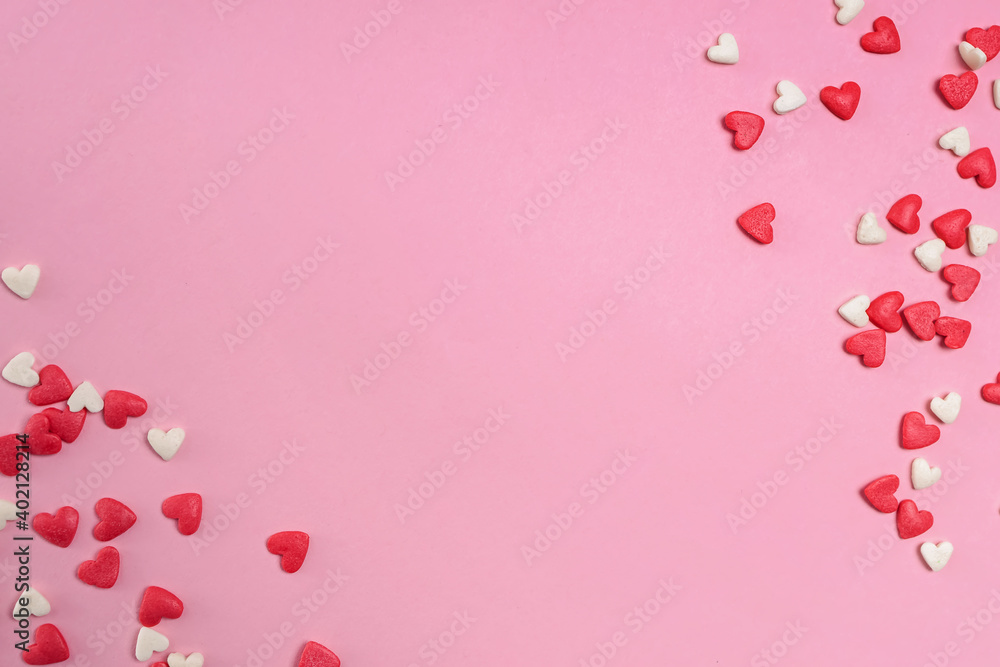 Sugar heart shaped sprinkles on pastel pink background