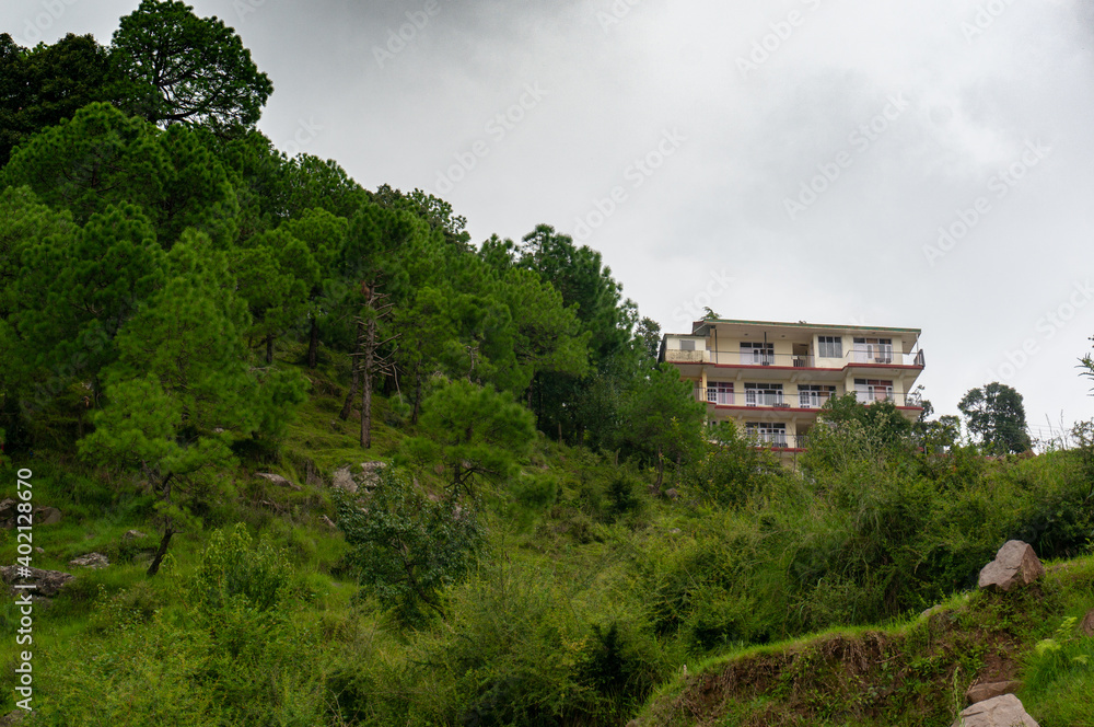Large concrete buildings of hotels homestays and residences in hill stations in India like Shimla, Dharamshala, Nainital and more which are popular tourist vacation and work remotely destinations