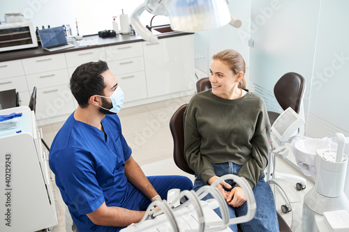 Top view of the multiracial dentist doctor and his blonde female patient