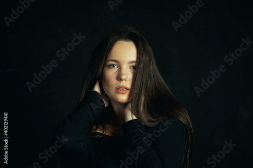 Portrait of a young beautiful woman in the studio on a dark background © fisher05