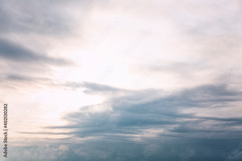 Fototapeta premium Beautiful blue dramatic sky with clouds at sunrise. Background. Space for text.