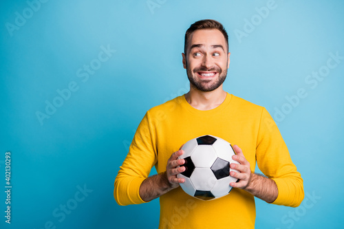 Photo portrait of man with ball smiling looking blank space curious isolated on bright blue color background © deagreez
