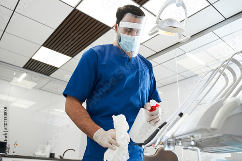 Male bearded dentist carefully sterilize the medical equipment