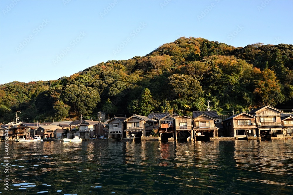Fototapeta premium View of Funaya, boat houses, with beautiful sun light at Ine bay in Autumn , Ine city, Kyoto, Japan - 京都 伊根の舟屋 秋の景色