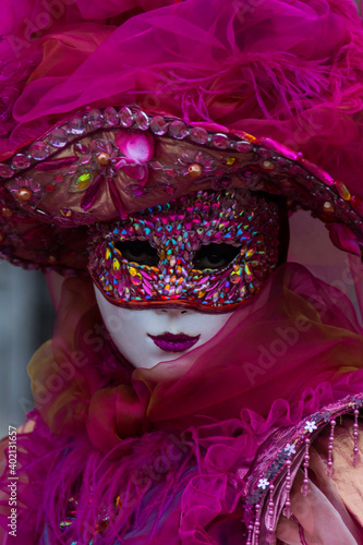 Fototapeta Naklejka Na Ścianę i Meble -  Venice, Italy - February 18, 2020: An unidentified woman in a carnival costume in front of Ponte dei Sospiri,  attends at the Carnival of Venice.