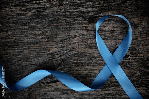 Top view of light blue ribbon on wooden background with copy space. Men's health and prostate cancer awareness and concept.