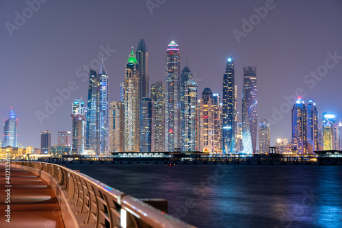 Night view to Dubai iconic skuscrappers panorama. Amazing illumination of the buildings reflected in the Gulf sea.  © Igor Shaposhnikov