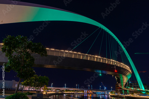 Night view to the Tolerance bridge illuminated with national green color of UAE. Amazing structure located at the Dubai water canal 