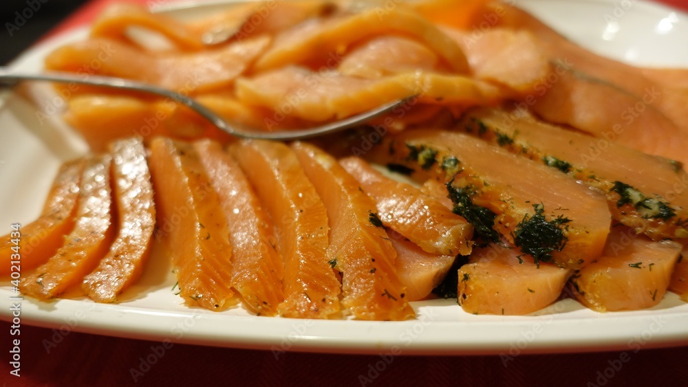 Seasoned and smoked salmon fillet sliced and served Seasoned and smoked salmon fillet sliced and served